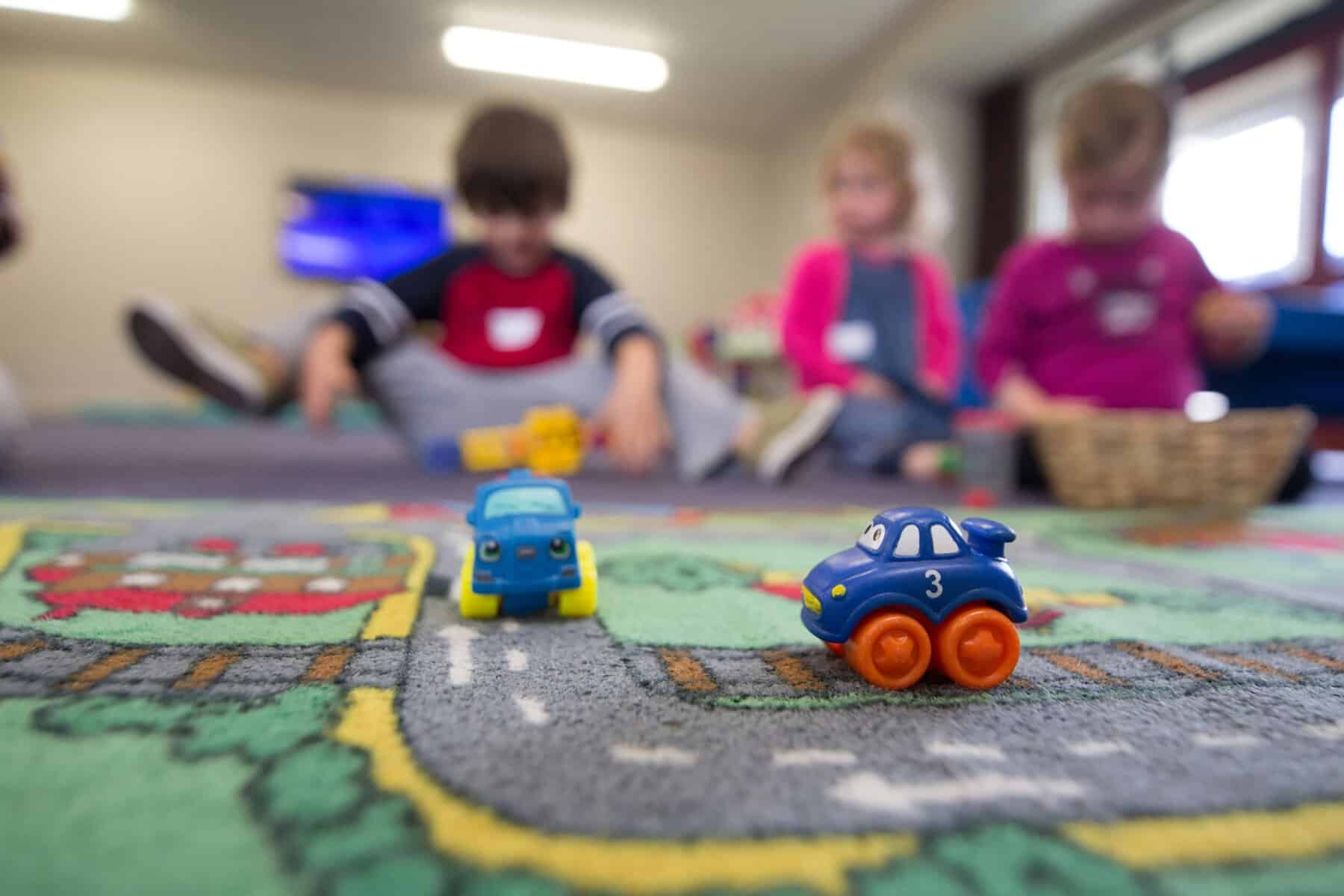 two toy cars on the floor of a modular nursery building